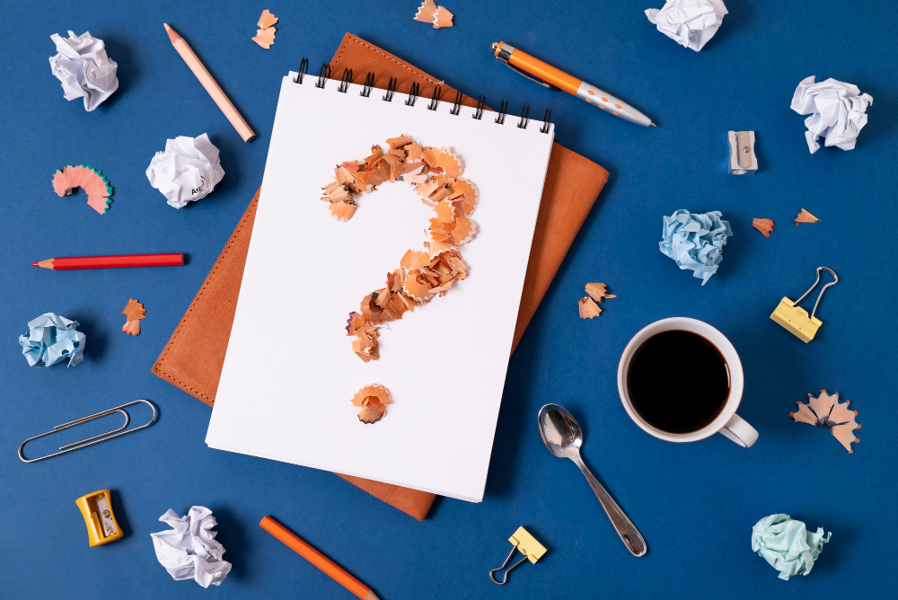 question mark on paper with coffee mug and stationary